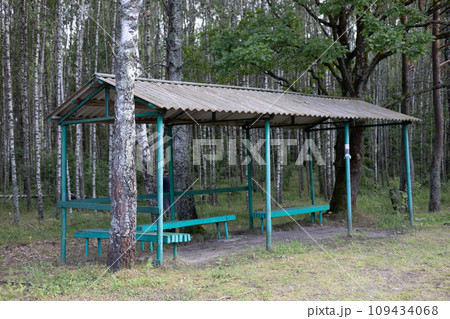 Old abandoned bus stop in the forest. In the forest on the outskirts of the road there is a bus stop that no one uses anymore. Bus stop deep in the forest. Old abandoned bus stop in the forest. In the forest on the outskirts of the road there is a bus stop that no one uses anymore. Bus stop deep in the forest. 109434068