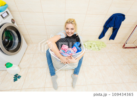 Woman with big basket of dirty clothes laundry. 109434365