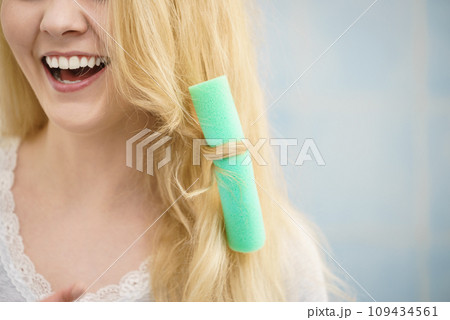 Blonde woman using hair rollers 109434561