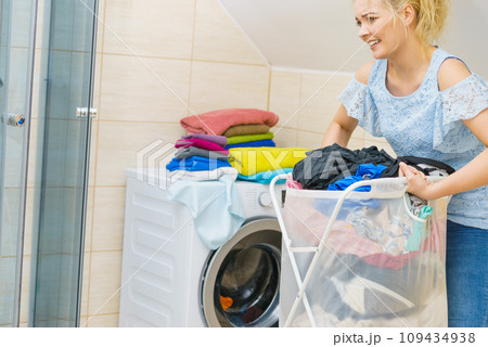 Woman holding laundry basket full of clothes 109434938
