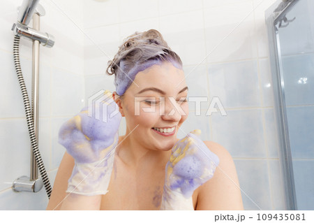 Woman applying toner shampoo on her hair 109435081