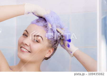 Woman applying toner shampoo on her hair Woman applying toner shampoo on her hair 109435082