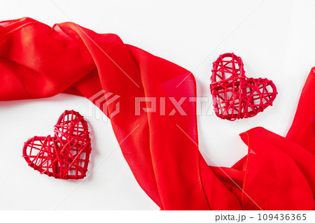 Red hearts and silk ribbon on a white background Red hearts and silk ribbon on a white background 109436365