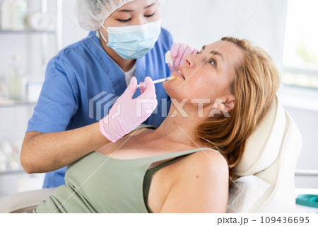 Qualified cosmetologist giving beauty injections for face skin rejuvenating and tightening for female client in aesthetic medicine office Qualified cosmetologist giving beauty injections for face skin rejuvenating and tightening for female client in aesthetic medicine office 109436695