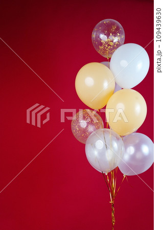 A bunch of light balloons on a red background. Vertical Photo Space for Text 109439630