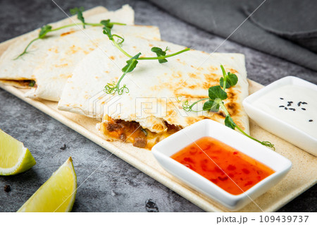 crispy flatbreads stuffed with meat, herbs, lime and two sauces, side view 109439737