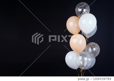 A bunch of balloons in white, beige and transparent colors on a dark background with space for an inscription A bunch of balloons in white, beige and transparent colors on a dark background with space for an inscription 109439799