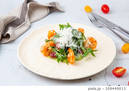 beautifully served shrimp with arugula and grated cheese, side view 109440013