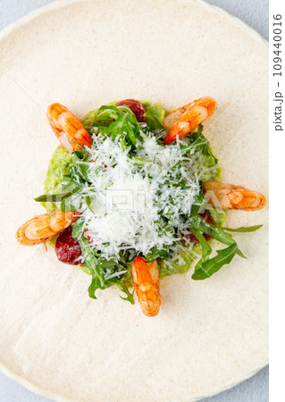 beautifully served shrimp with arugula and grated cheese, side view 109440016