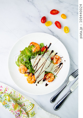 shrimp with avocado slices and arugula with teriyaki sauce side view 109440024