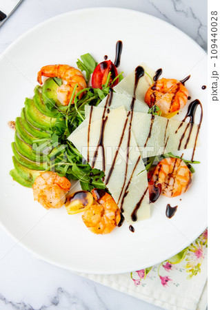 shrimp with avocado slices and arugula with teriyaki sauce side view shrimp with avocado slices and arugula with teriyaki sauce side view 109440028
