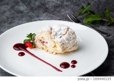 meringue roll with drops of berry jam side view 109440135