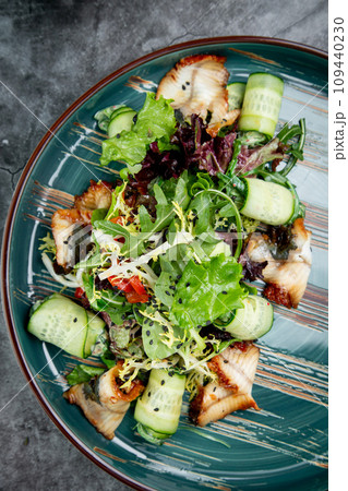 salad with arugula, lettuce, cucumber rolls, fish and sesame seeds, top view salad with arugula, lettuce, cucumber rolls, fish and sesame seeds, top view 109440230