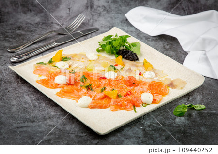 sliced red and white fish with mozzarella cheese and herbs, top view sliced red and white fish with mozzarella cheese and herbs, top view 109440252