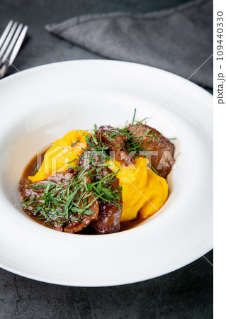 mashed potatoes with meat, sauce and herbs in a deep plate side view mashed potatoes with meat, sauce and herbs in a deep plate side view 109440330