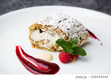 sweet sponge dessert with raspberries and powdered sugar side view 109440384