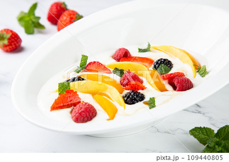 raspberry, peach, strawberry, black berry, strawberry and mint in whipped cream, side view 109440805