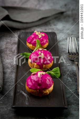 dessert of baked buns with raspberry topping and seed decorations, side view dessert of baked buns with raspberry topping and seed decorations, side view 109441001