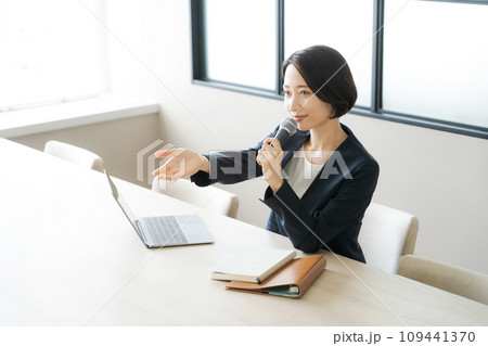 マイクを持って話をするビジネスパーソン 109441370