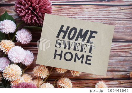 Home Sweet Home text message with flower decoration on wooden background 109441643