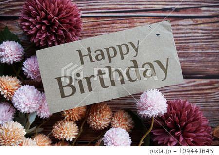 Happy Birthday text message with flower decoration on wooden background Happy Birthday text message with flower decoration on wooden background 109441645