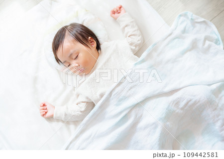 部屋で眠る1歳児　お昼寝　バンザイ寝 109442581