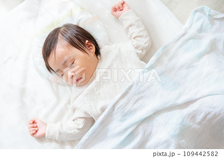 部屋で眠る1歳児 お昼寝 バンザイ寝 部屋で眠る1歳児 お昼寝 バンザイ寝 109442582