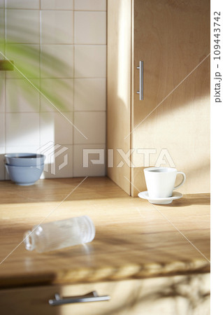 A sunny kitchen with white tile walls, a wooden table and sink. A sunny kitchen with white tile walls, a wooden table and sink. 109443742