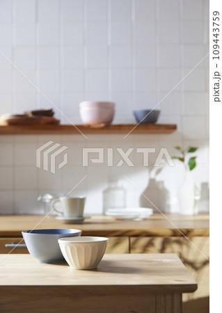 A sunny kitchen with white tile walls, a wooden table and sink. A sunny kitchen with white tile walls, a wooden table and sink. 109443759