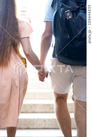Tourism, travel. Young people couple holding hands walking through the city 109444835