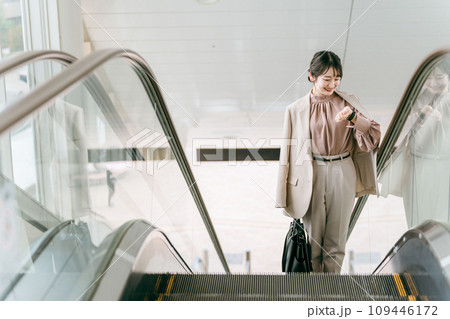 空港・駅のエスカレーターで腕時計を見るビジネスウーマン(出勤・通勤) 空港・駅のエスカレーターで腕時計を見るビジネスウーマン(出勤・通勤) 109446172