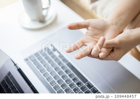 Close-up,Hand of asian woman massaging her palm,suffering from trigger finger disease,tendon problem,pain in hand and fingers,trigger finger from typing on keyboard for long period of time,health care 109448457