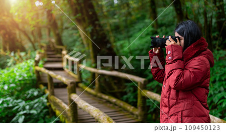Female photographer taking nature pictures inside the rainforest 109450123