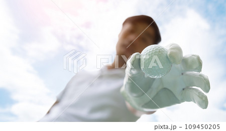 Golfer putting golf ball on tee on golf course Golfer putting golf ball on tee on golf course 109450205