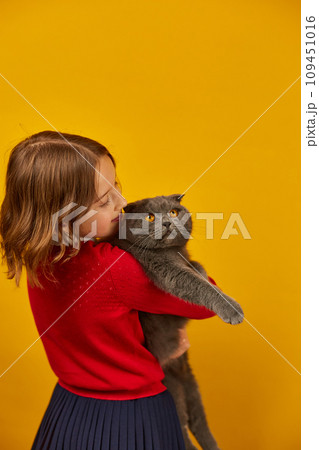 Portrait of the beautiful teen girl hugging her grey fat cat Portrait of the beautiful teen girl hugging her grey fat cat 109451016