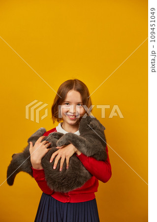 Portrait of the beautiful teen girl hugging her grey fat cat Portrait of the beautiful teen girl hugging her grey fat cat 109451049