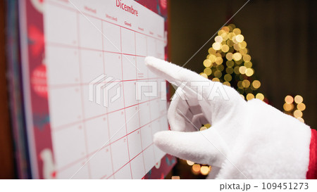 Santa Claus organizing his work with a calendar 109451273