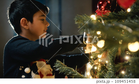 Kid Lighting a Christmas tree for holidays 109451458