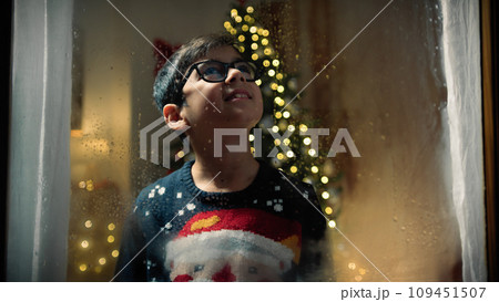 child at the window on Christmas night child at the window on Christmas night 109451507
