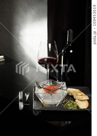 salmon fish caviar, on ice, with croutons, lemon, on a transparent dish, on a dark background salmon fish caviar, on ice, with croutons, lemon, on a transparent dish, on a dark background 109453019