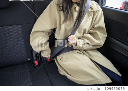 後部座席でシートベルトをする人物 後部座席でシートベルトをする人物 109453076