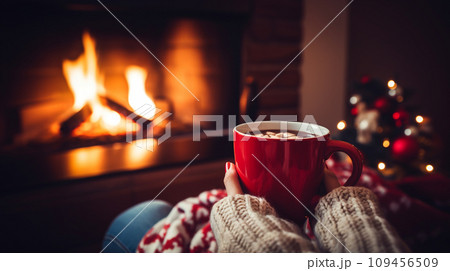 Mug of hot drink near fireplace 109456509