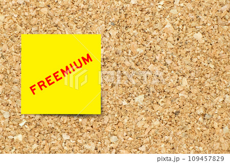 Yellow note paper with word freemium on cork board background with copy space 109457829