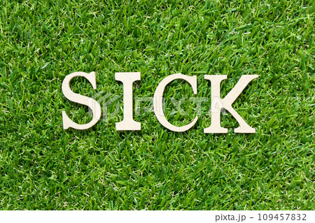 Wood letter in word sick on green grass background 109457832