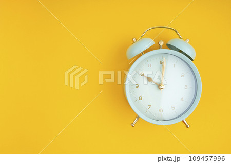 Retro alarm clock on yellow background. Position with copy space. 109457996