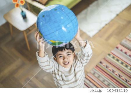 地球儀のビーチボールを持った7歳の男の子 地球儀のビーチボールを持った7歳の男の子 109458110