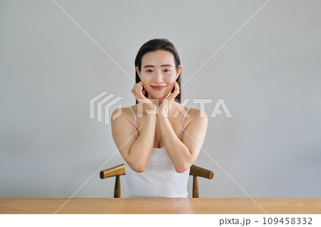 顔をマッサージして肌のお手入れをする30代女性 109458332