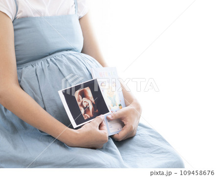 妊婦女性がエコー写真と母子手帳を持っているイメージ 109458676