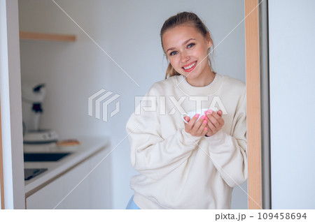 Smiling cute girl having coffee in the kitchen 109458694