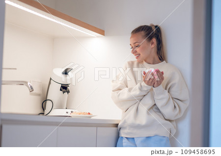 Smiling cute girl having coffee in the kitchen 109458695